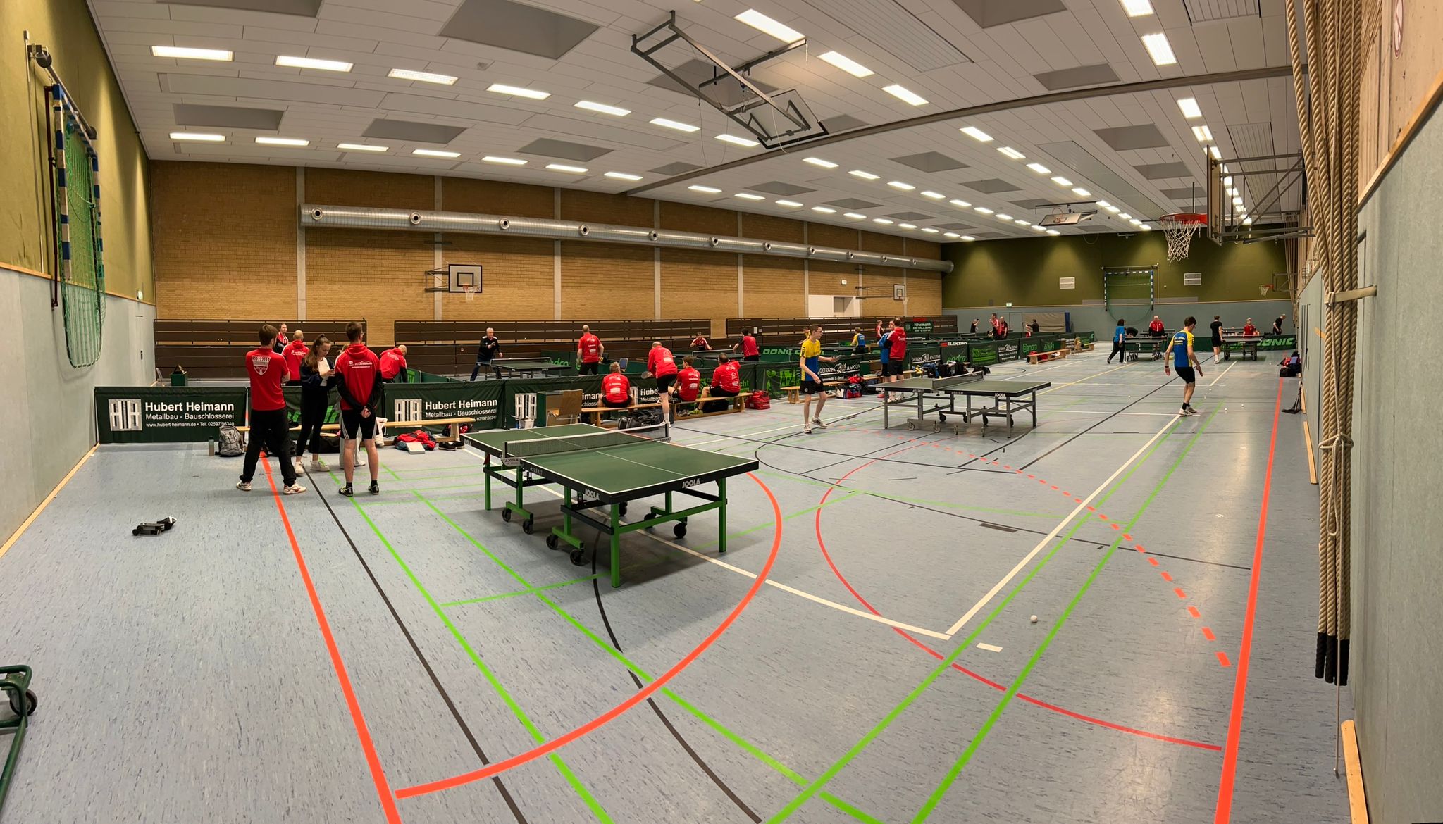 Tischtennisspielerinnen und -spieler an vielen Platten in unserer Sporthalle